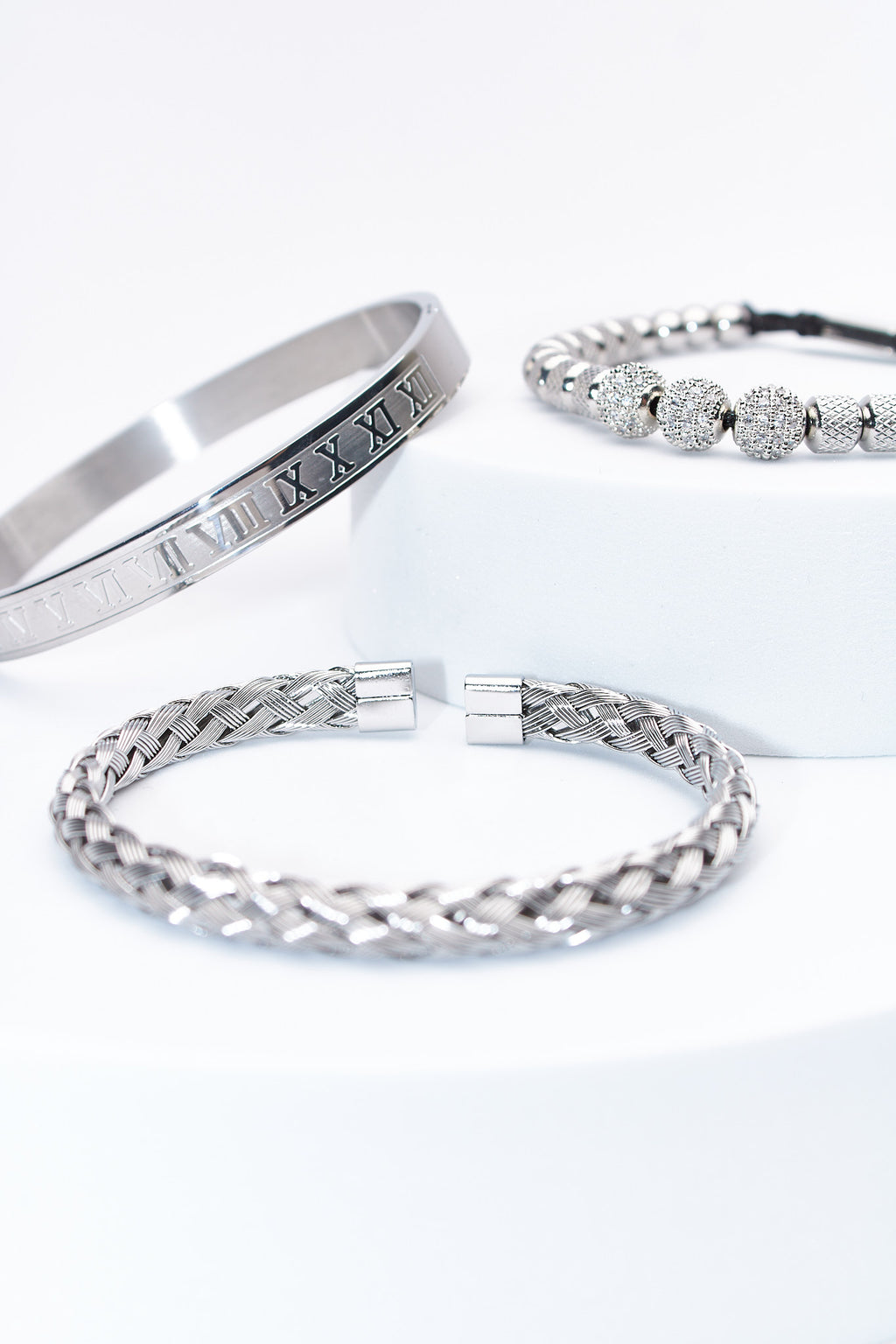 Set de pulseras plateadas — pulsera rígida con numerales + trenzada + cuentas pavé