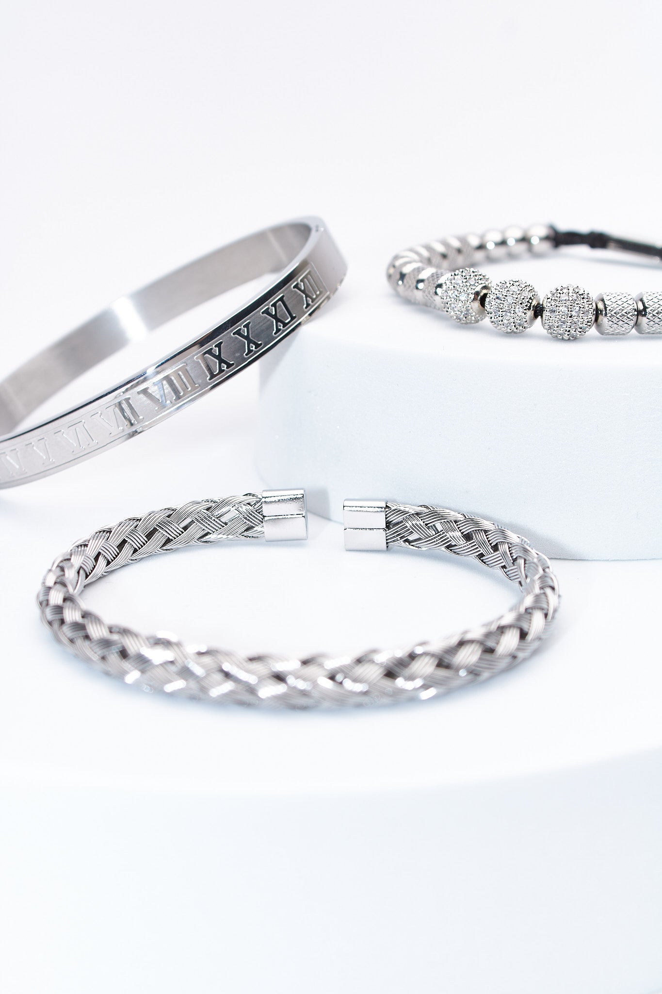 Set de pulseras plateadas — pulsera rígida con numerales + trenzada + cuentas pavé