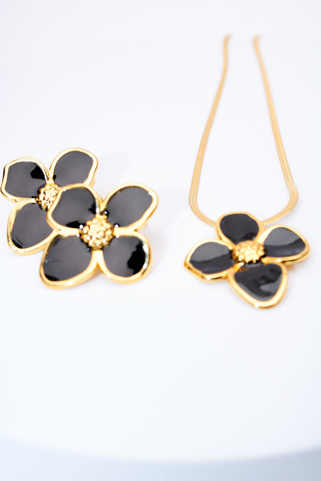 Set flor esmaltada negra — collar serpiente + broches flor, baño dorado