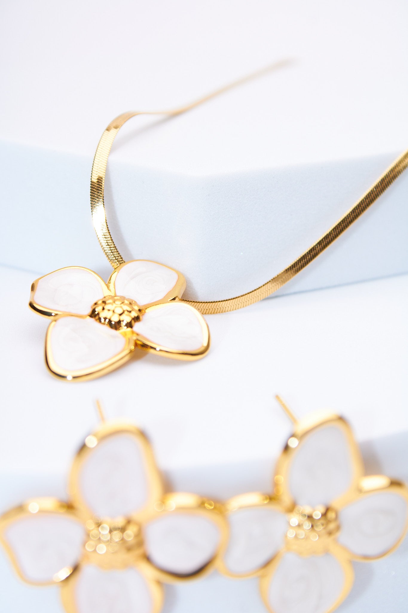 Set flor esmaltada blanca — collar serpiente + aretes flor, baño dorado