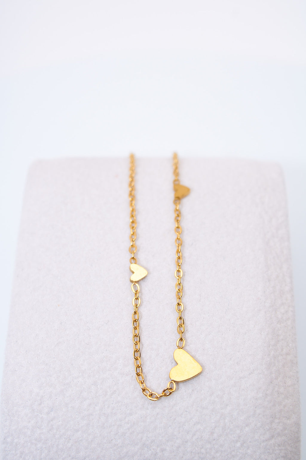 Pulsera fina con corazones espaciados — baño dorado