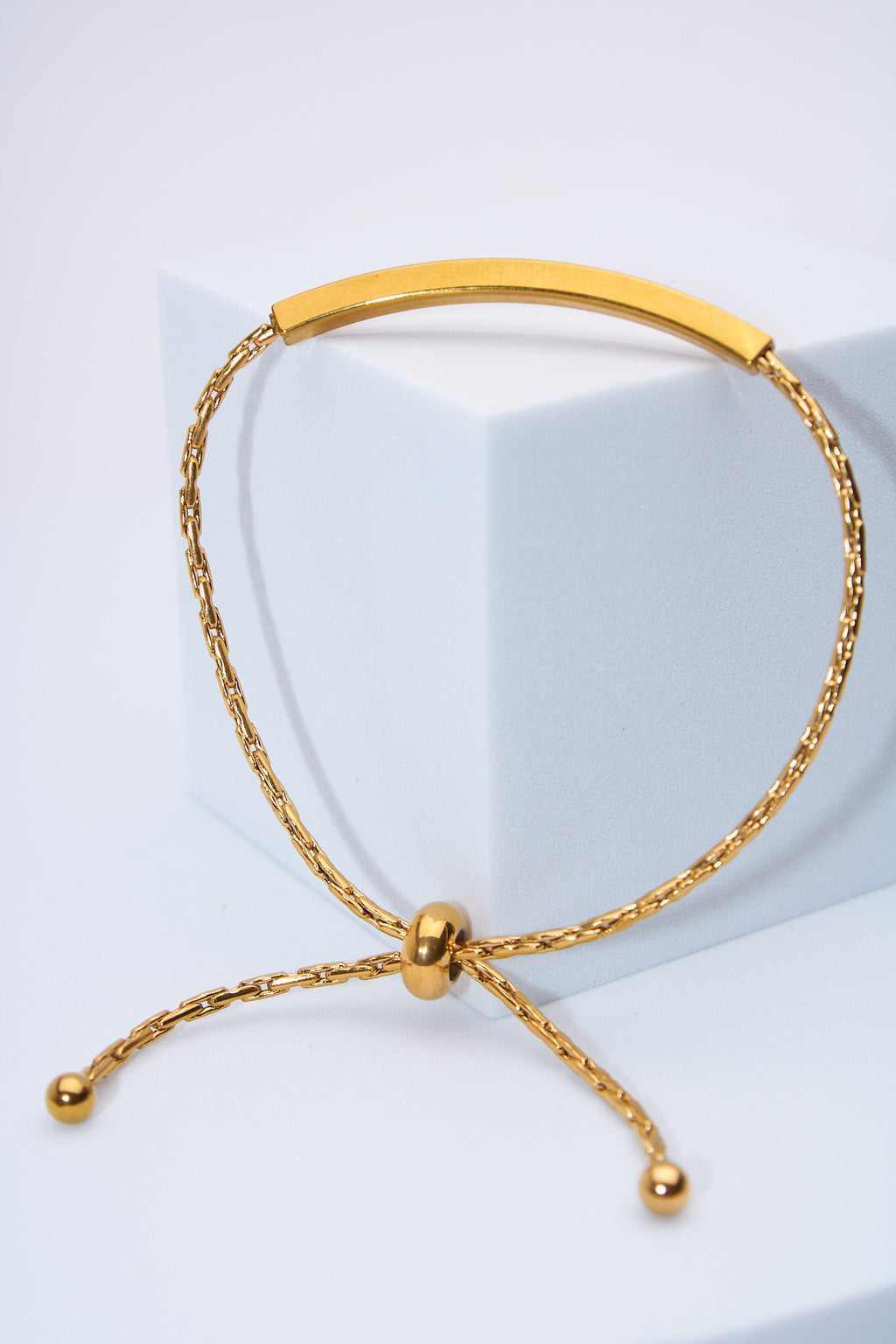 Pulsera ajustable barra curva dorada — cierre deslizante