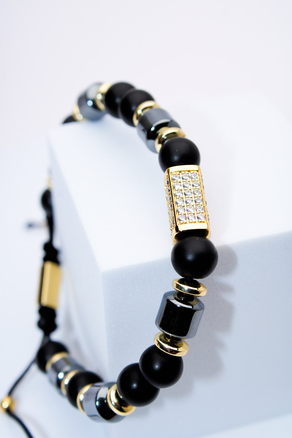 Pulsera ajustable de cuentas negras con detalle pavé dorado
