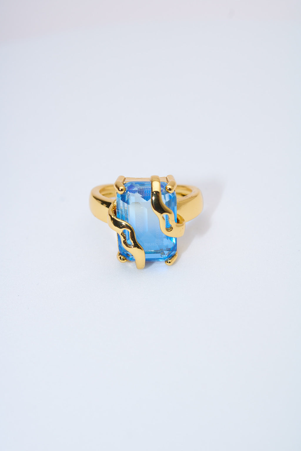 Anillo con piedra azul facetada — baño dorado