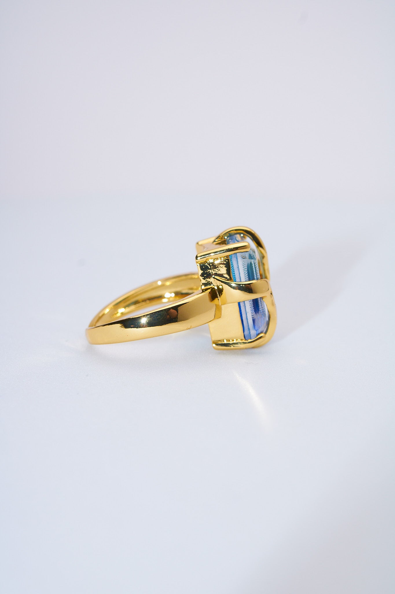 Anillo con piedra azul facetada — baño dorado