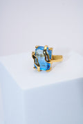 Anillo con piedra azul facetada — baño dorado