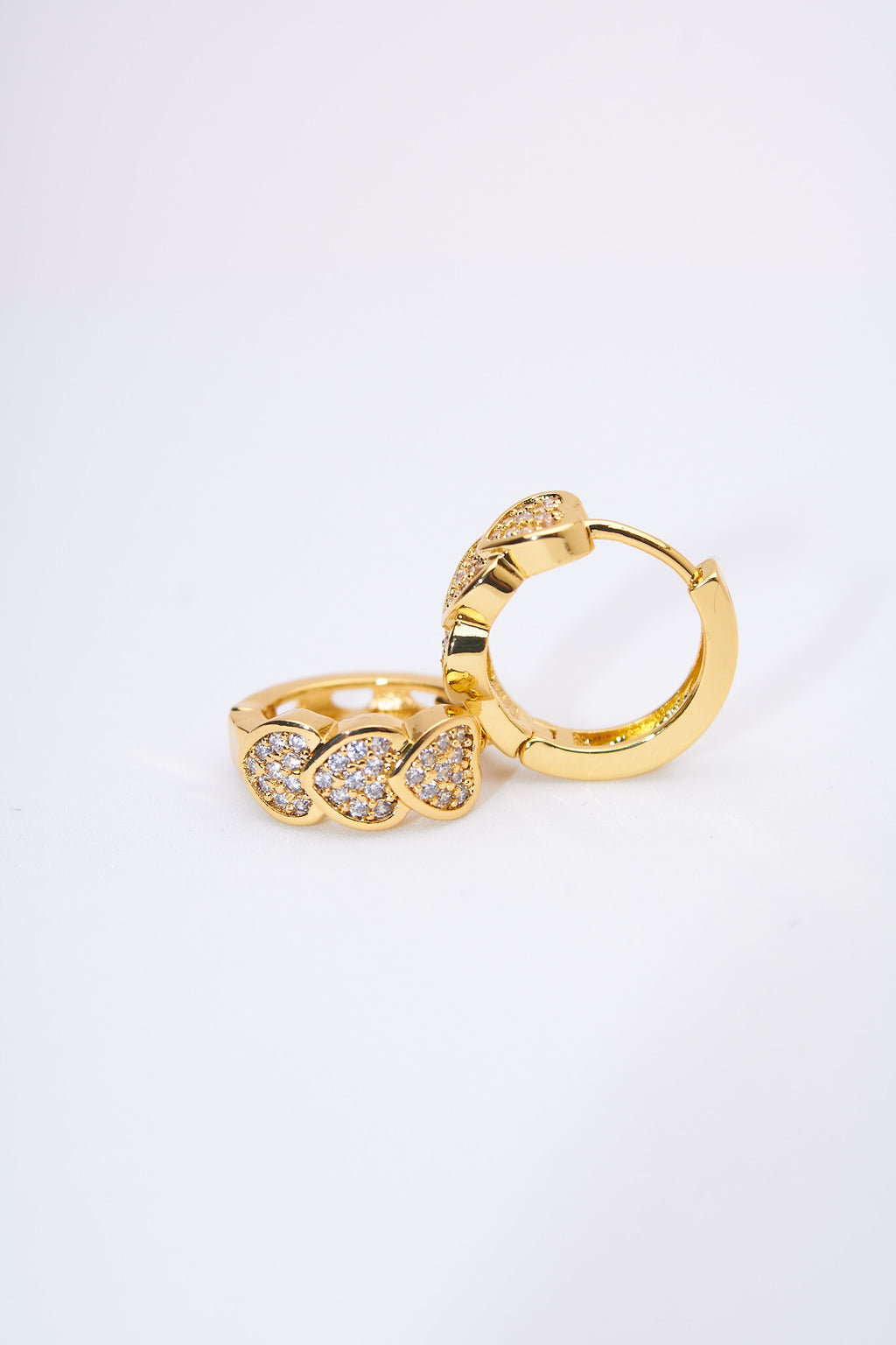 Aretes huggie corazones pavé dorados