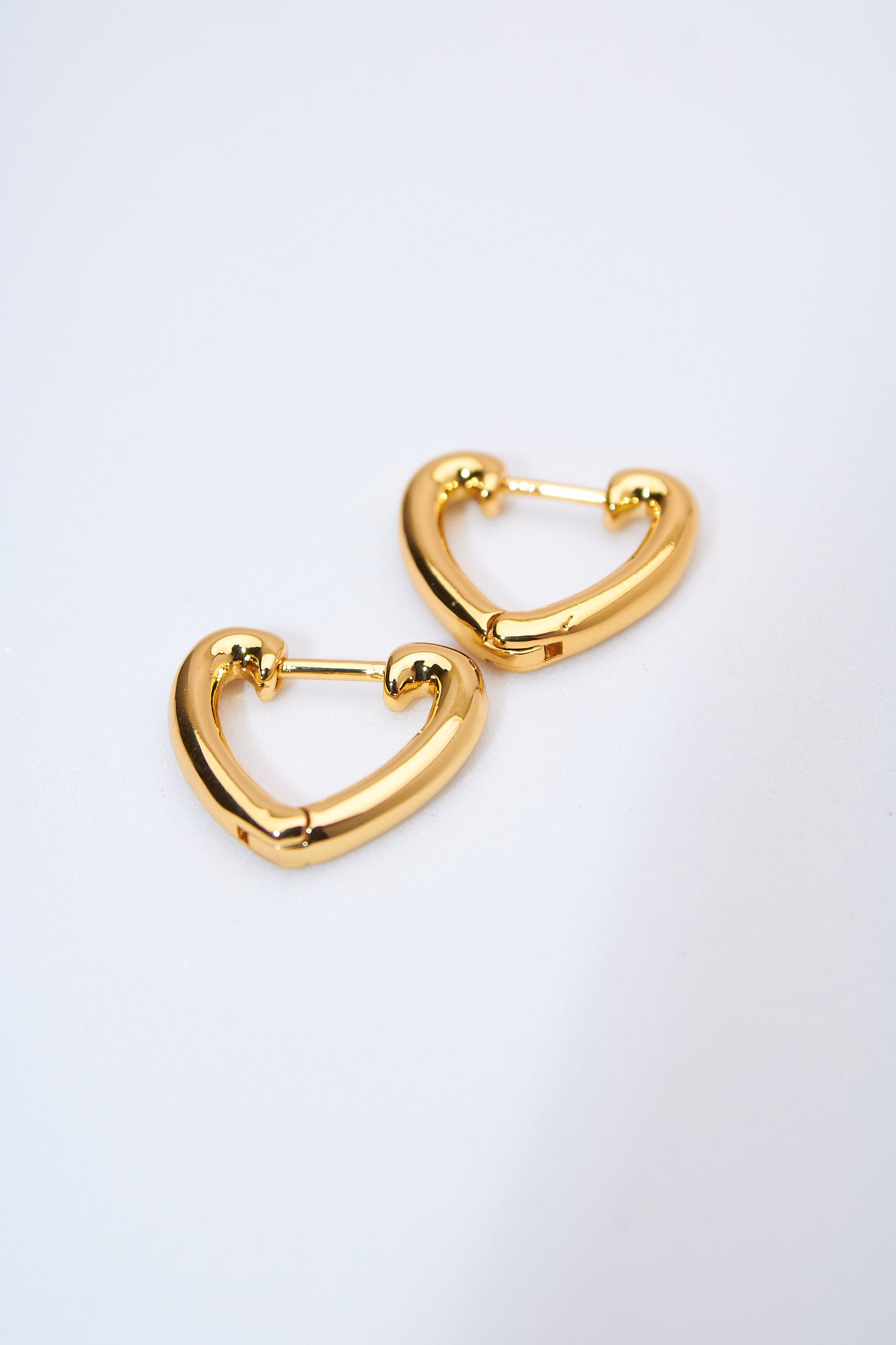 Aretes corazón hueco dorados — acabado pulido