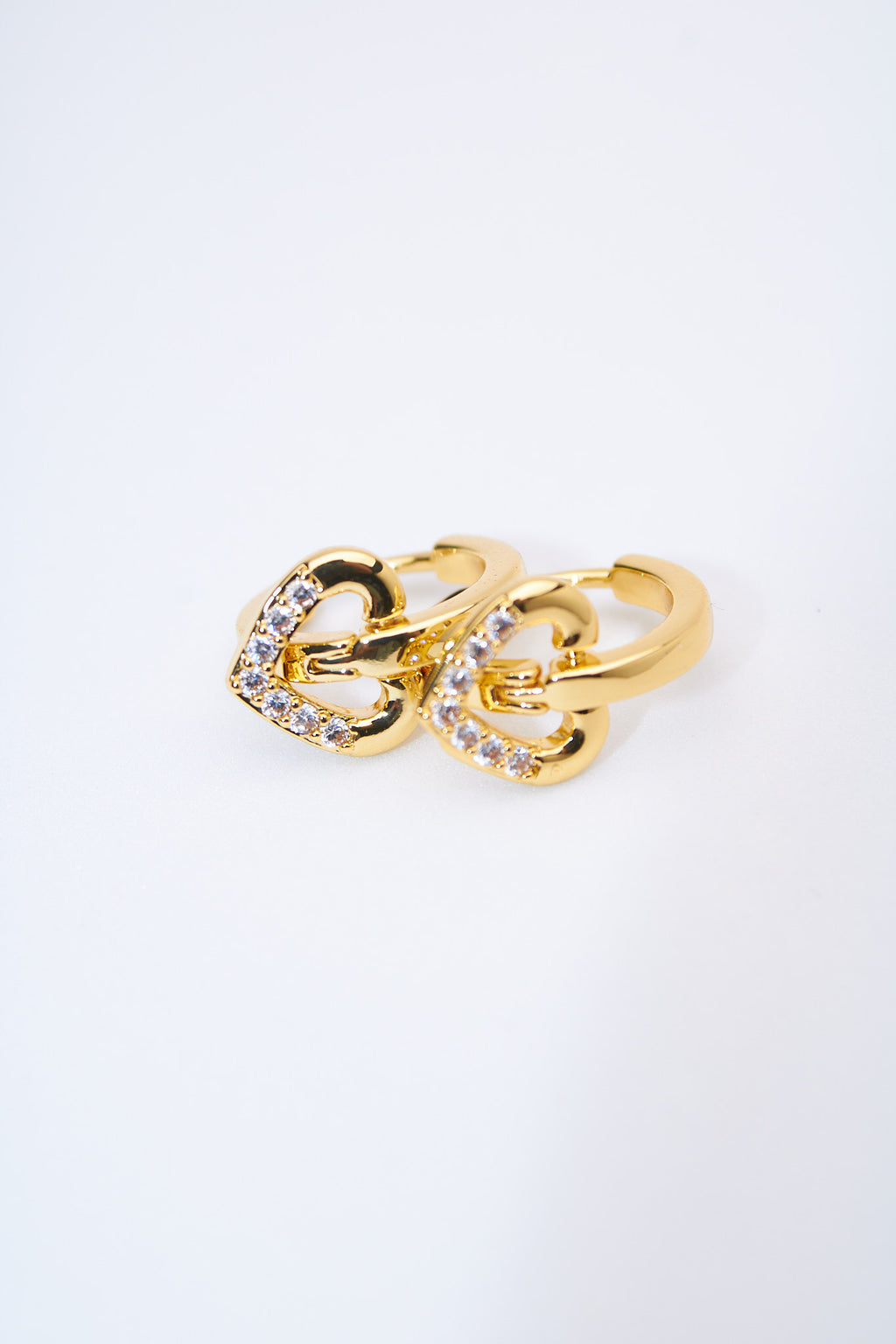 Aretes huggie con corazones pavé dorados