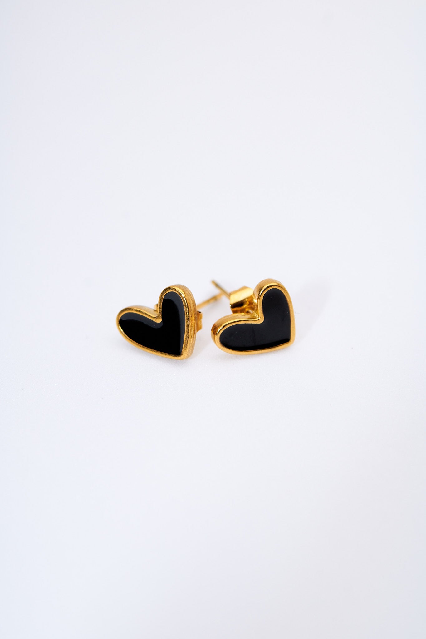 Aretes corazón esmaltado negro — marco dorado