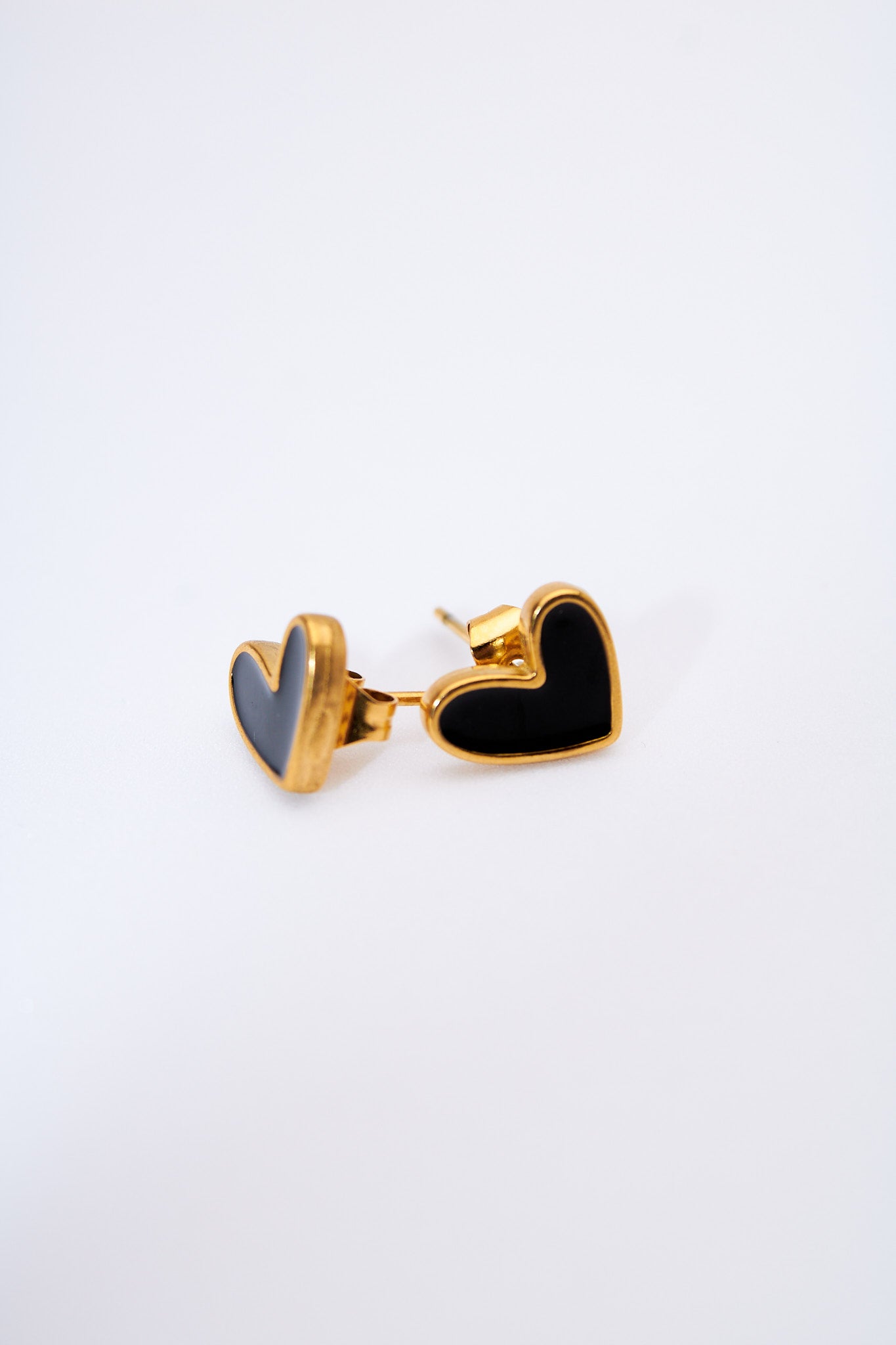 Aretes corazón esmaltado negro — marco dorado